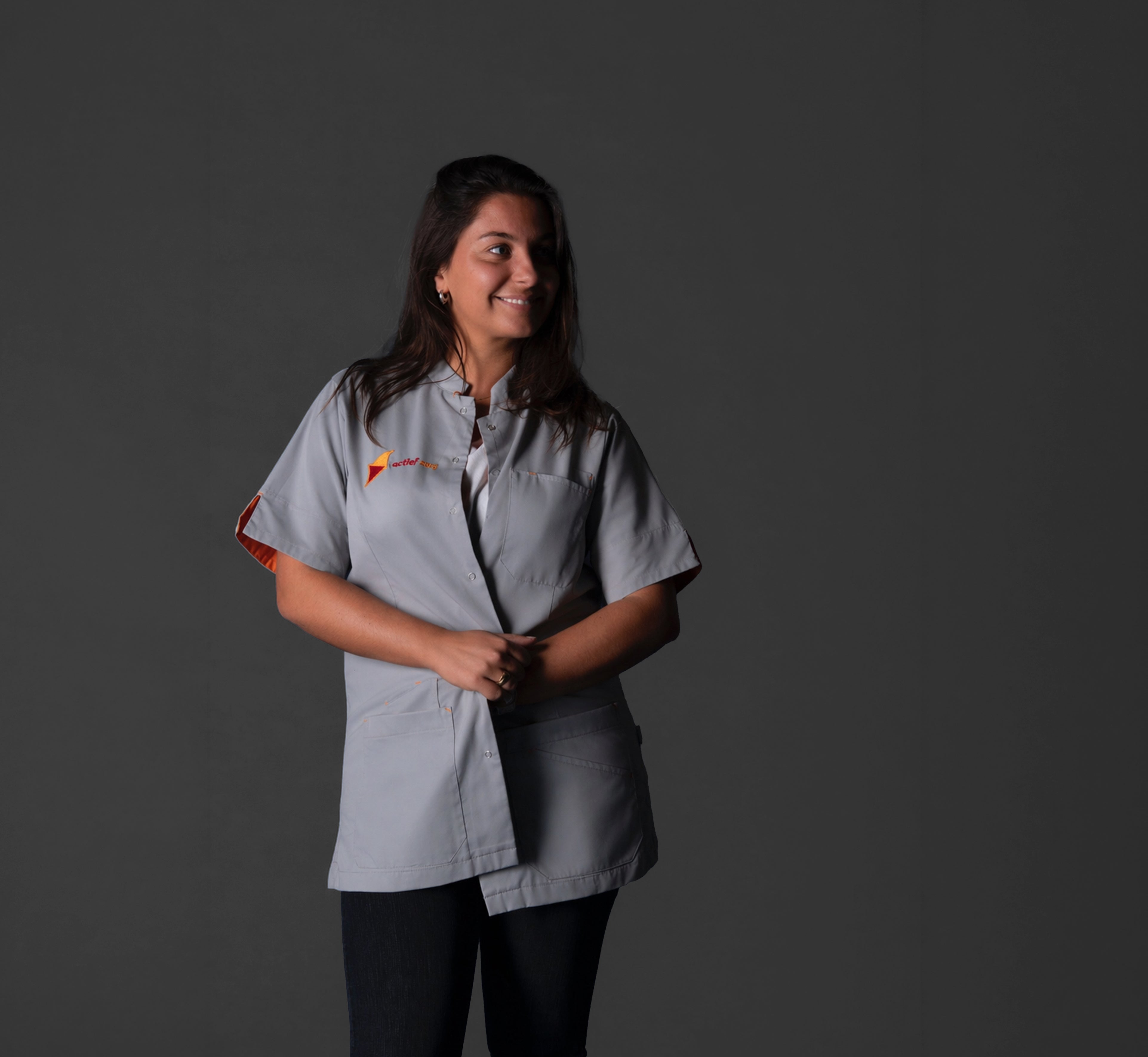 Vrouw met op maat gemaakte jas met logo in de zorg